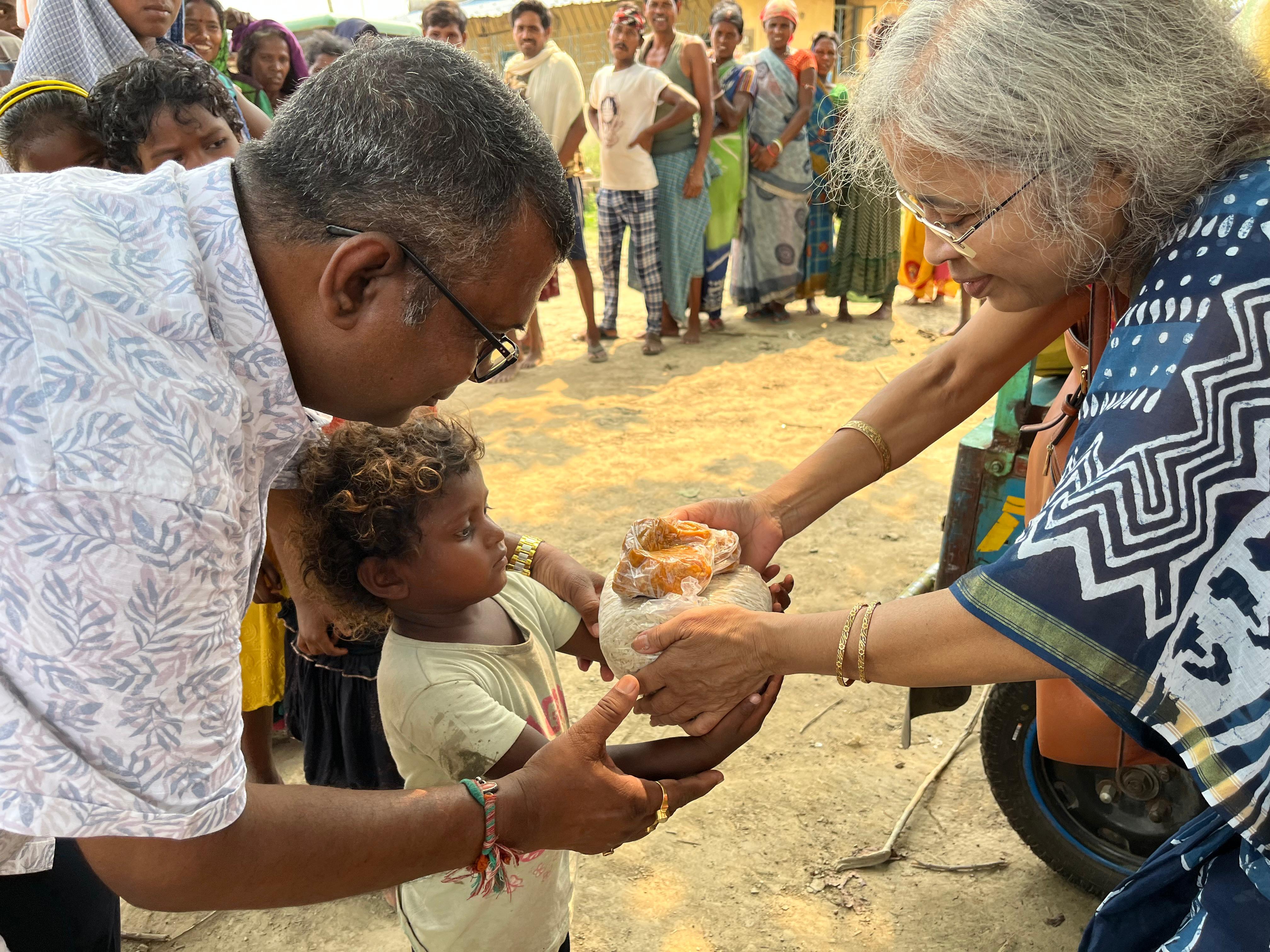 Founder & Vice-Chairman of Radha Kishori Trust, Mr. Naresh Chandra Das donating food to a child in an 'Anna Daan' event.